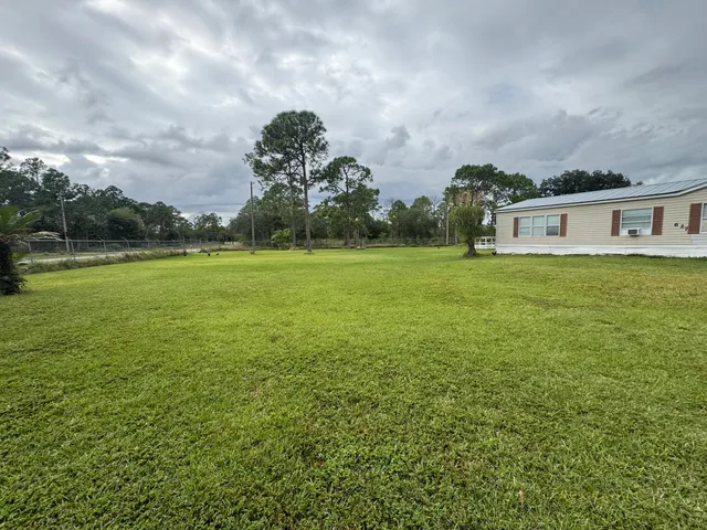 a view of a big yard with a house in the background