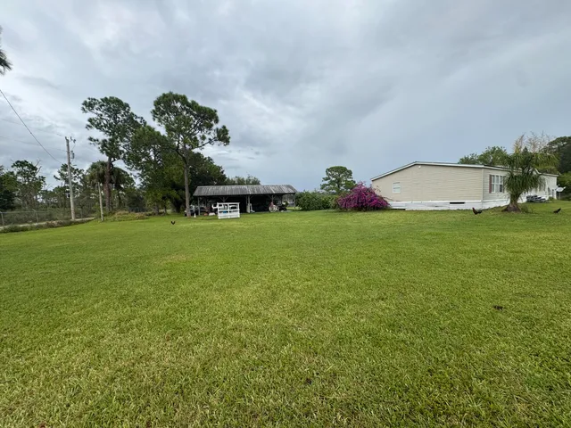a view of a house with a yard and sitting area