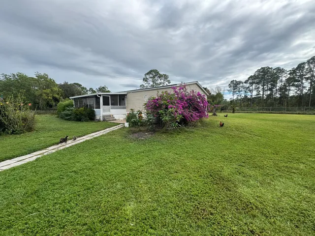 a front view of a house with plants