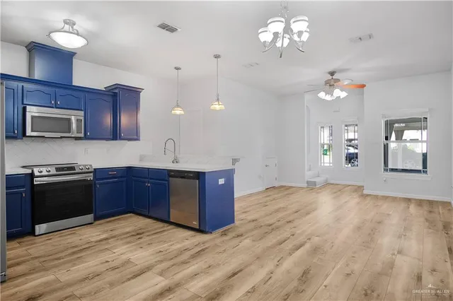 a kitchen with kitchen island granite countertop wooden floors granite counter tops and white cabinets