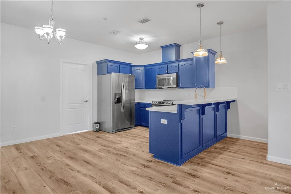 1309 West Fig Avenue, Unit A Pharr, TX 78577 - Photo 6 of 15 a kitchen with stainless steel appliances granite countertop wooden cabinets a refrigerator a sink and a stove