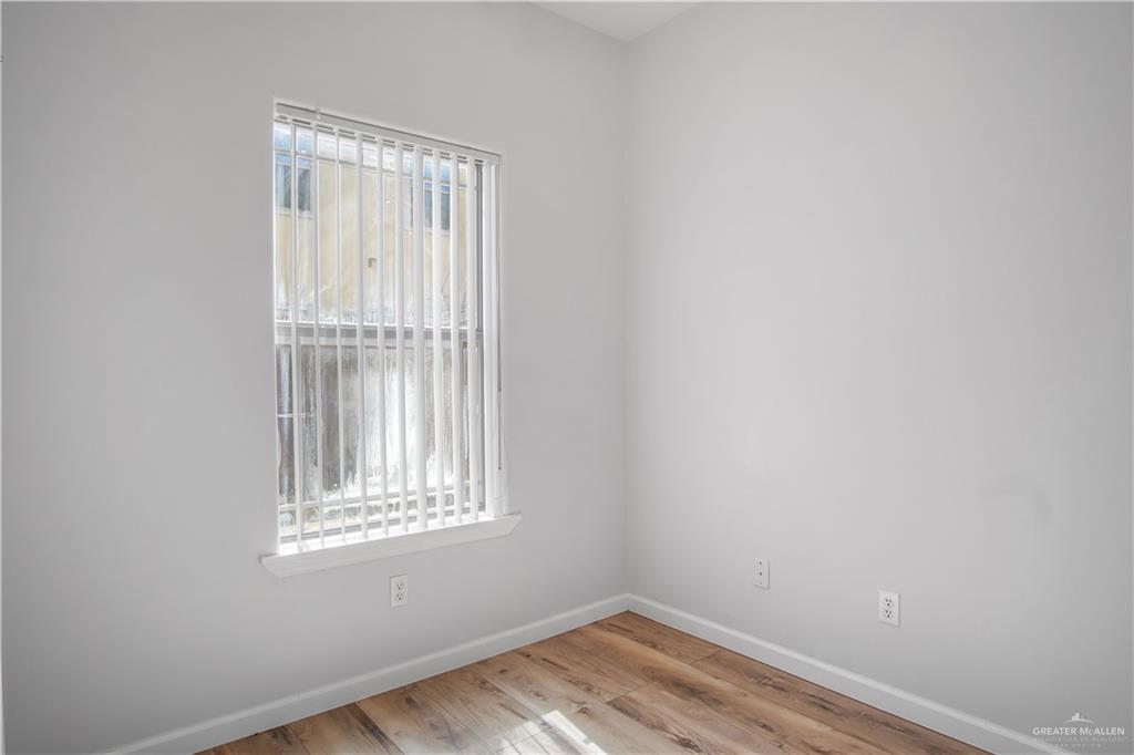 1309 West Fig Avenue, Unit A Pharr, TX 78577 - Photo 9 of 15 a view of an empty room with wooden floor and a window