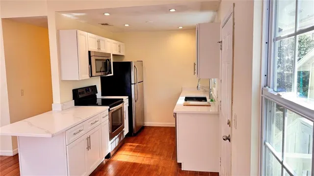 a kitchen with a refrigerator and a stove top oven