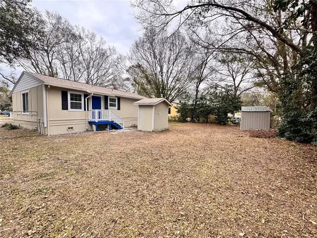 a front view of house with yard and trees around