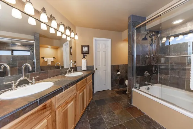 a large spacious bathroom with a tub sink shower and mirror