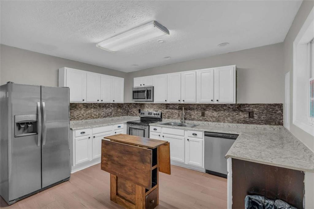 11118 City Pond Road Covington, GA 30014 - Photo 11 of 24 a kitchen with a refrigerator stove top oven and sink