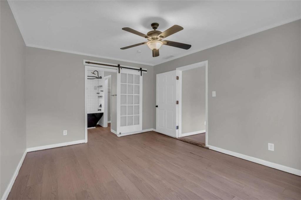 11118 City Pond Road Covington, GA 30014 - Photo 12 of 24 a view of an empty room with chandelier fan and wooden floor