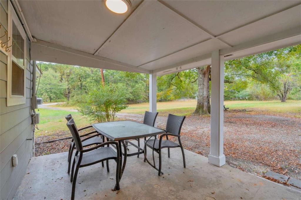 11118 City Pond Road Covington, GA 30014 - Photo 19 of 24 a view of a patio with a table chairs and a backyard