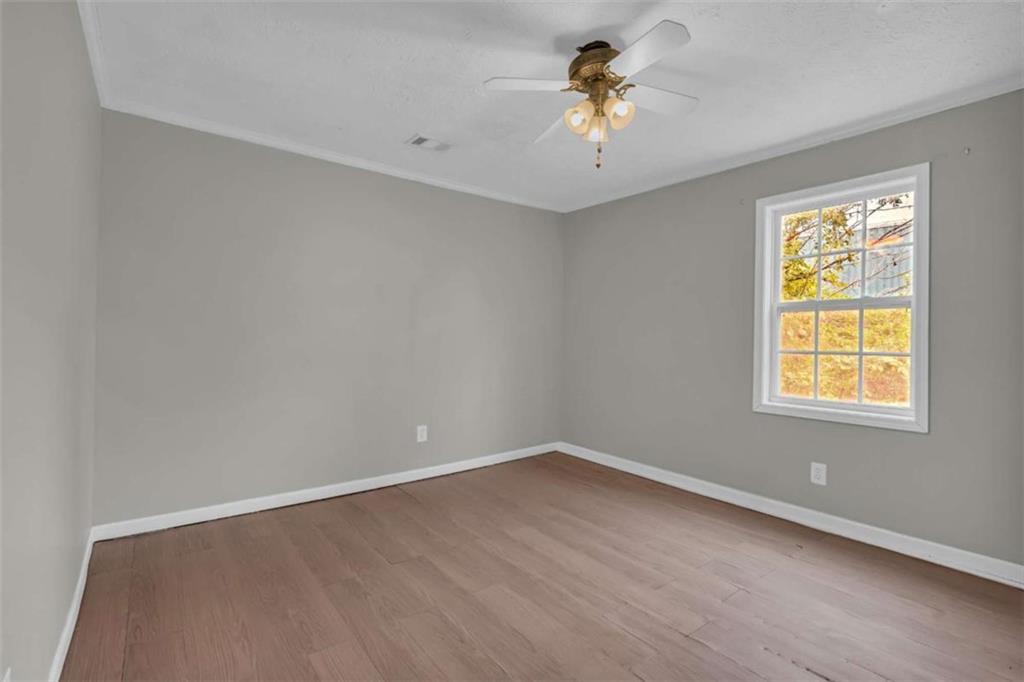 11118 City Pond Road Covington, GA 30014 - Photo 8 of 24 an empty room with a window and a ceiling fan