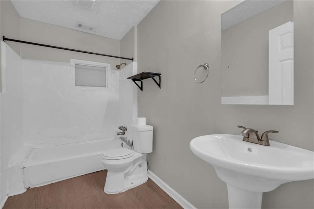11118 City Pond Road Covington, GA 30014 - Photo 9 of 24 a bathroom with a sink a toilet and shower
