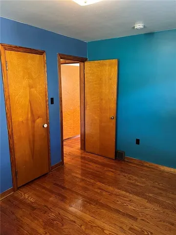 an empty room with wooden floor and a window