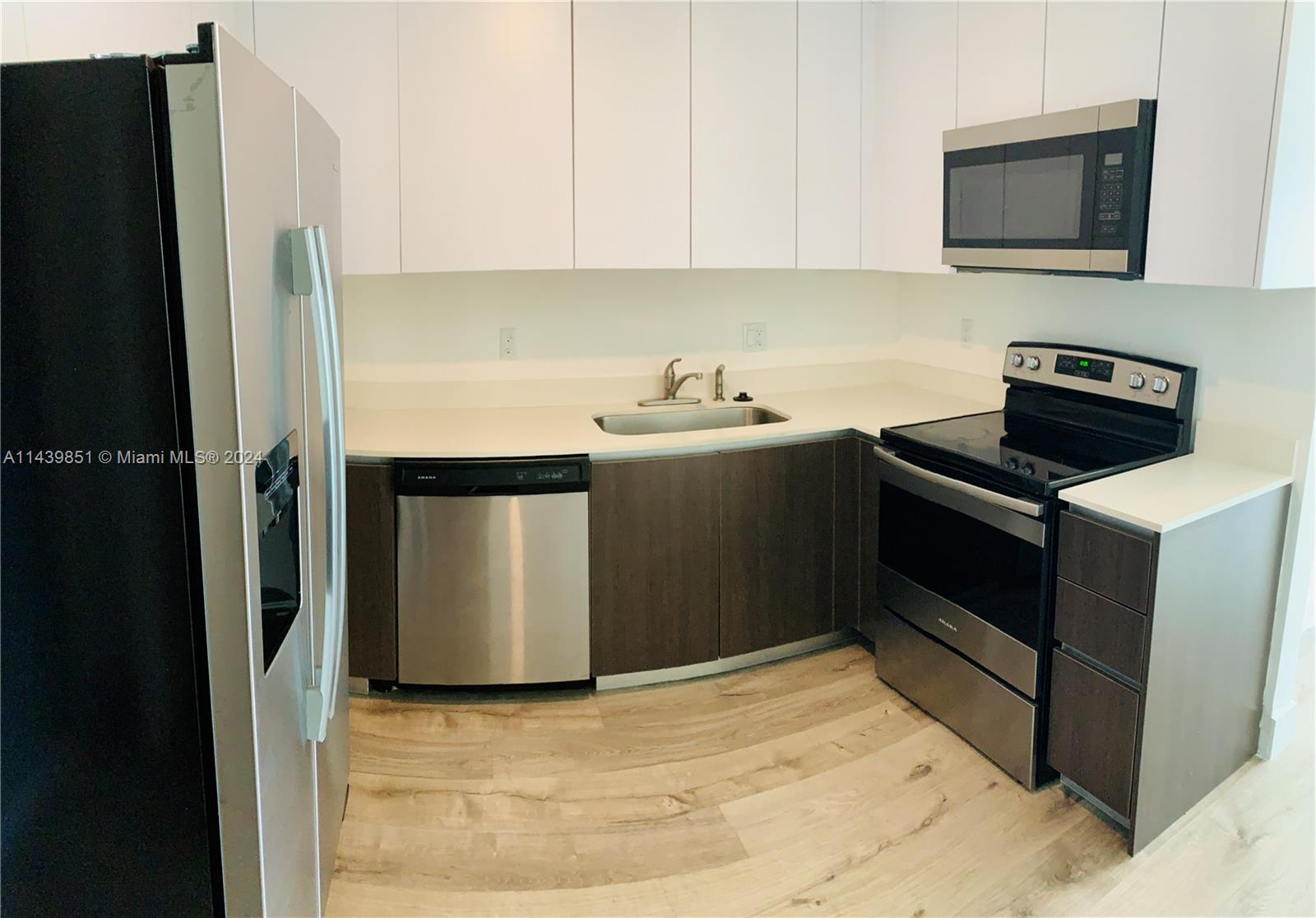 a kitchen with a stove refrigerator and microwave