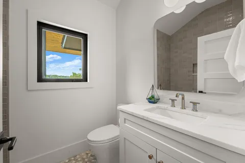 a bathroom with a toilet a sink and mirror