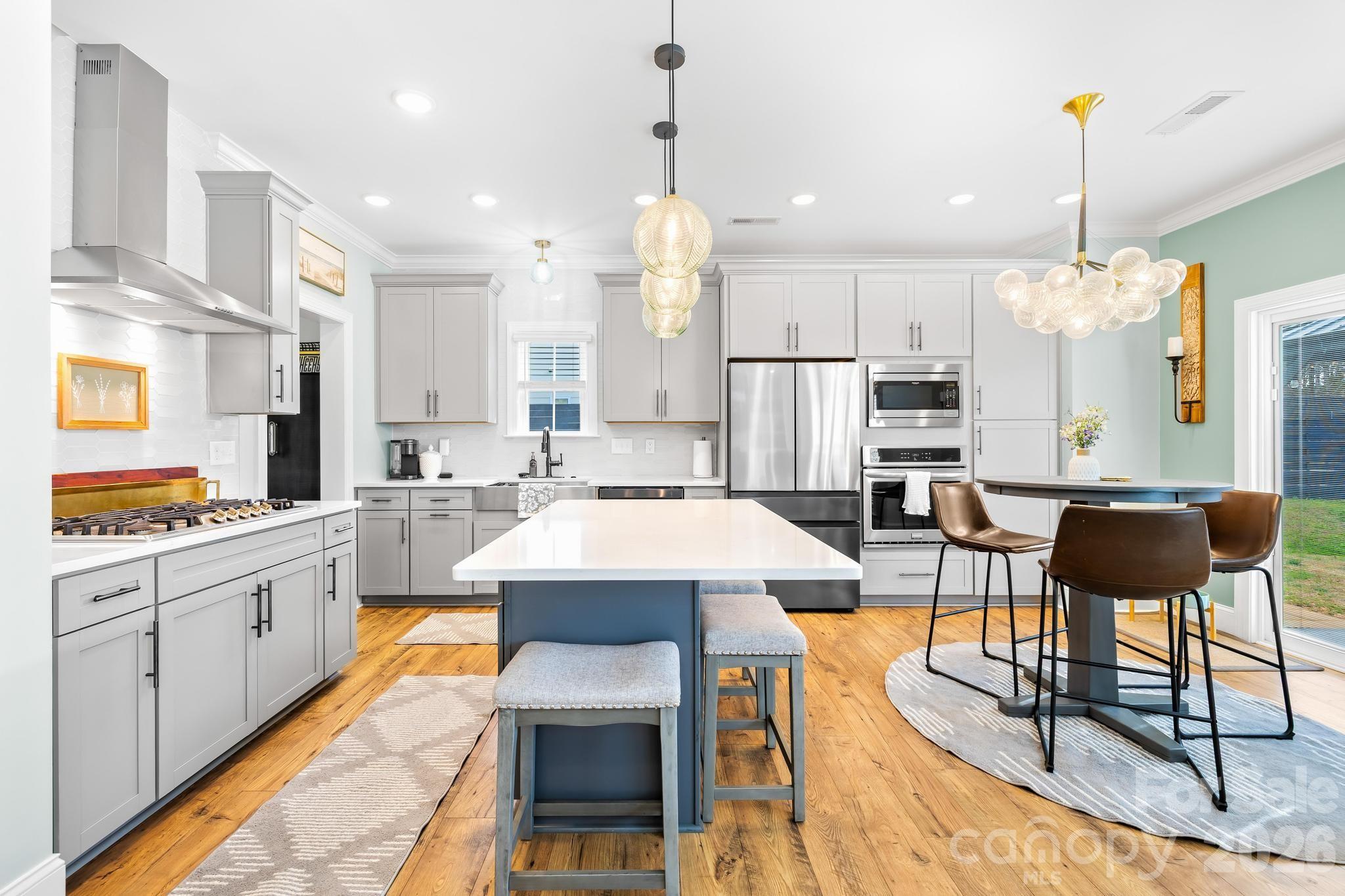 2509 St James Church Road Denver, NC 28037 - Photo 11 of 41 a large kitchen with a table chairs stove and white cabinets
