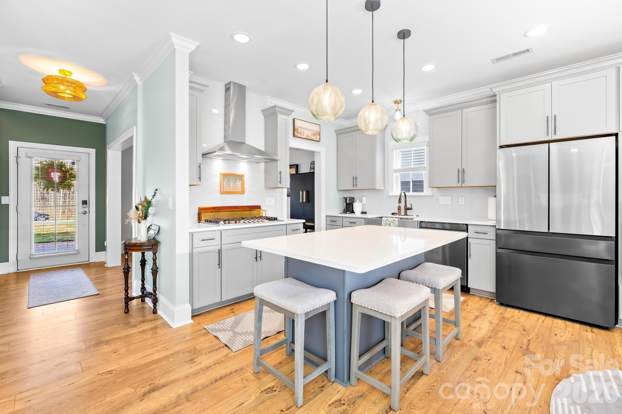 2509 St James Church Road Denver, NC 28037 - Photo 12 of 41 a kitchen with stainless steel appliances kitchen island granite countertop a kitchen island a stove a sink a dining table and chairs with wooden floor