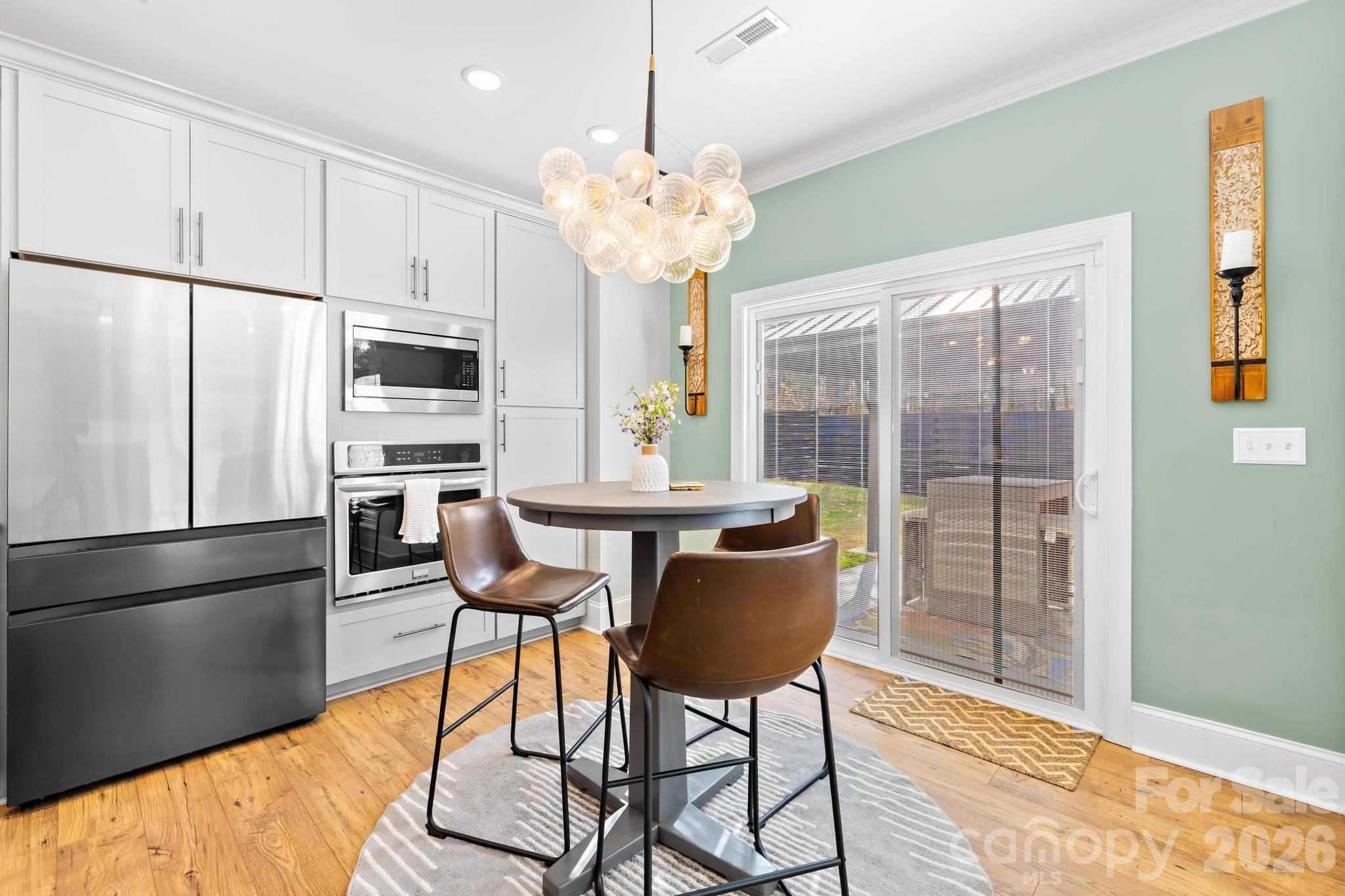 2509 St James Church Road Denver, NC 28037 - Photo 14 of 41 a kitchen with stainless steel appliances granite countertop a refrigerator a sink dishwasher a dining table and chairs with wooden floor