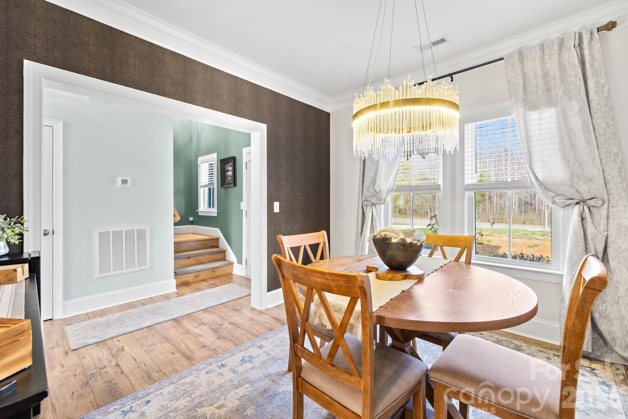 2509 St James Church Road Denver, NC 28037 - Photo 6 of 41 a dining room with furniture a chandelier and wooden floor
