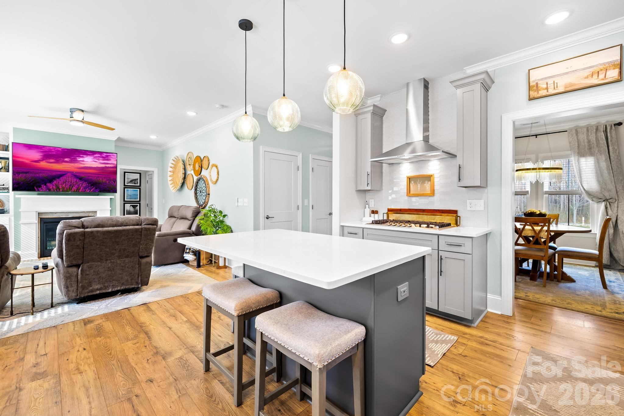 2509 St James Church Road Denver, NC 28037 - Photo 10 of 41 a open kitchen with stainless steel appliances kitchen island granite countertop a stove a sink a dining table and chairs with wooden floor