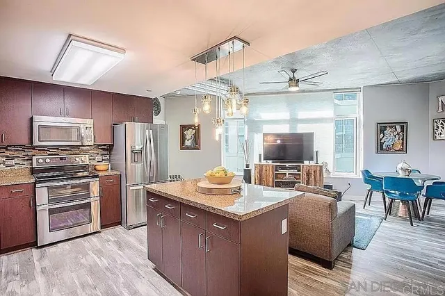a kitchen with stainless steel appliances granite countertop a sink dishwasher stove and refrigerator