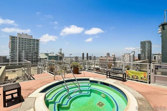 a swimming pool with outdoor seating and city view