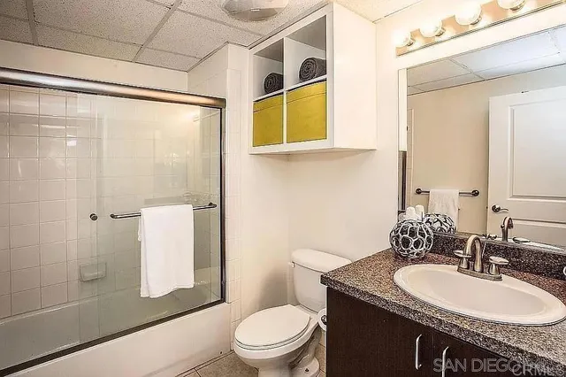 a bathroom with a granite countertop sink toilet and shower