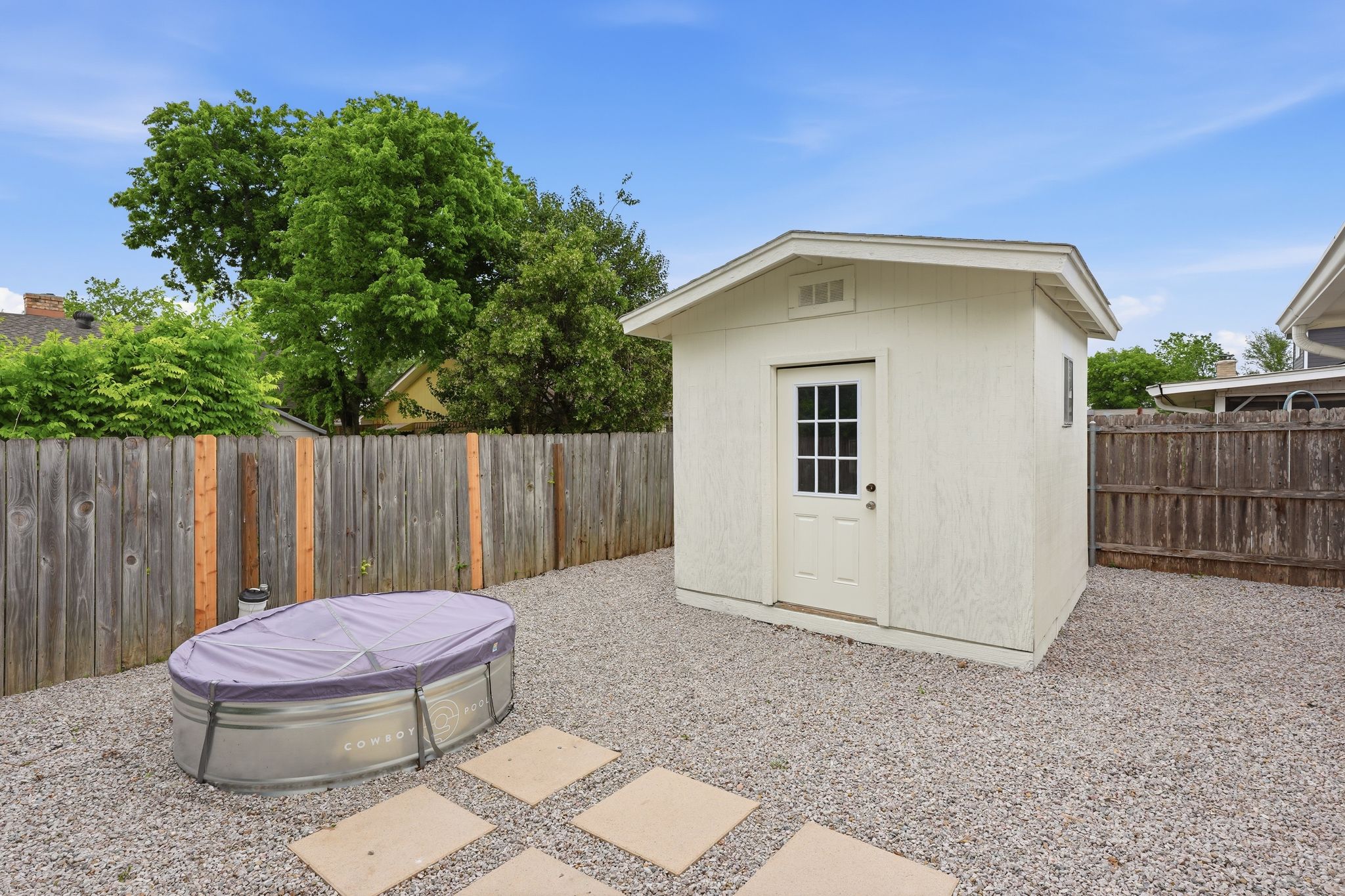 6804 Meadow Run Austin, TX 78745 - Photo 33 of 34 The property includes a gravel yard with a storage shed, featuring a paneled door with glass inserts and a small window