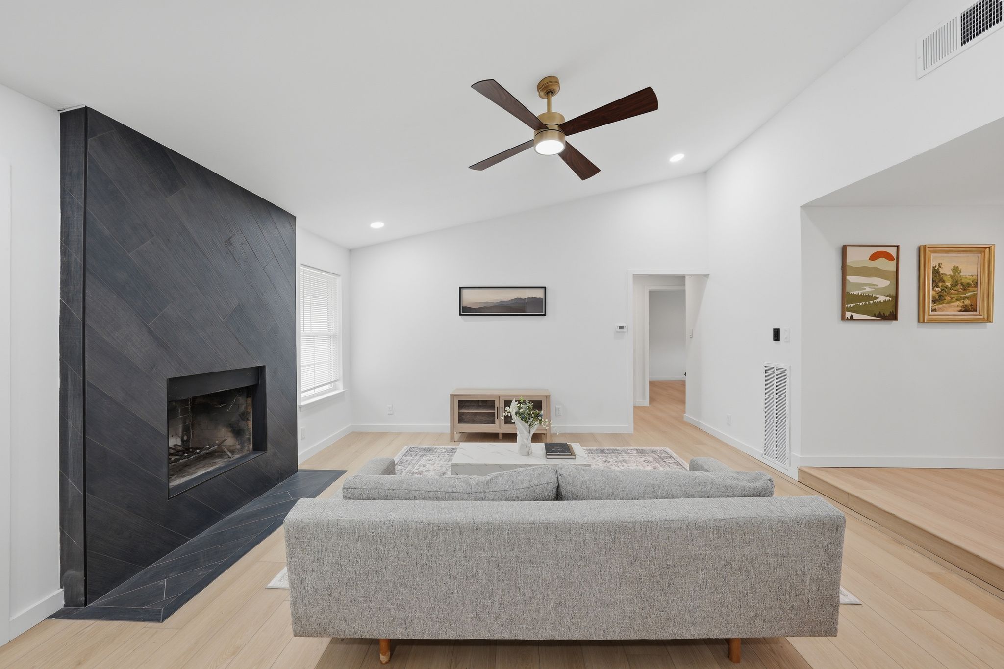 6804 Meadow Run Austin, TX 78745 - Photo 7 of 34 Living area featuring a distinctive angled black tile fireplace and light wood flooring