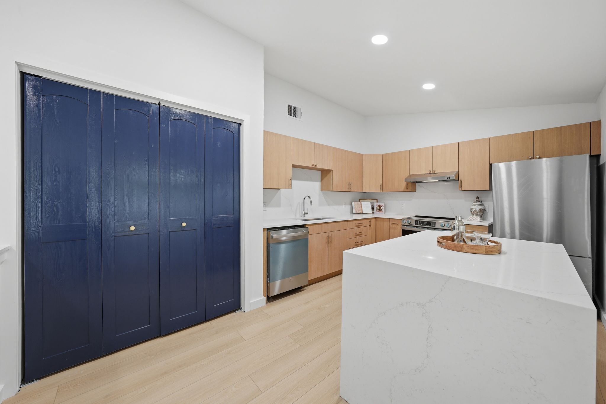 6804 Meadow Run Austin, TX 78745 - Photo 9 of 34 The kitchen features light wood cabinetry, stainless steel appliances, and a large central island with a light-colored countertop