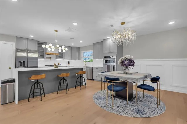 a dining room filled chandelier and kitchen view