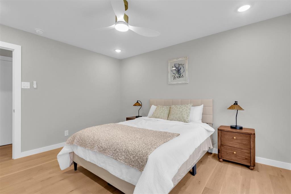 11107 Hillcrest Road Dallas, TX 75230 - Photo 18 of 29 a spacious bedroom with a bed and a chandelier