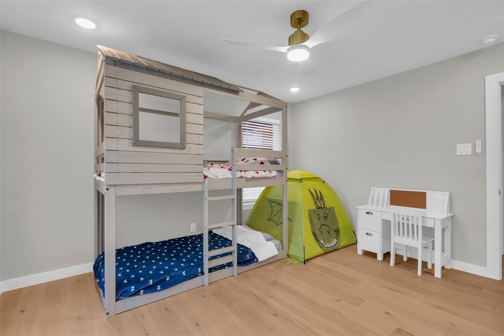 11107 Hillcrest Road Dallas, TX 75230 - Photo 20 of 29 a bedroom with a bed and a chandelier