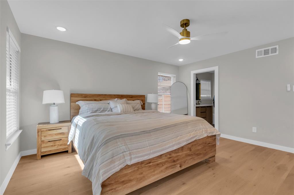 11107 Hillcrest Road Dallas, TX 75230 - Photo 22 of 29 a bedroom with a bed and a chandelier