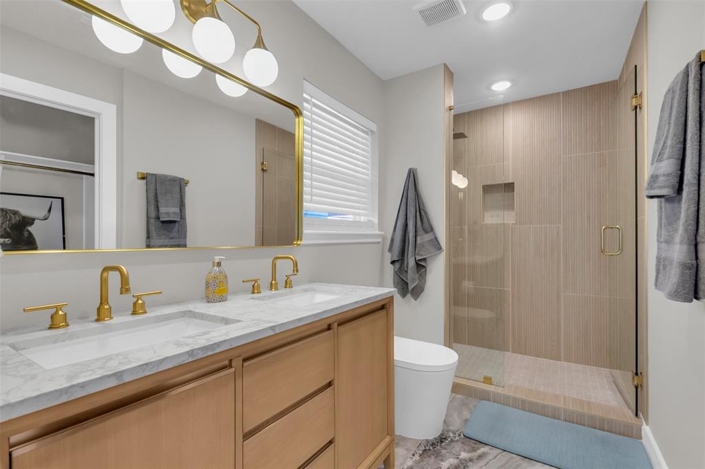 11107 Hillcrest Road Dallas, TX 75230 - Photo 23 of 29 a bathroom with a granite countertop sink toilet and shower