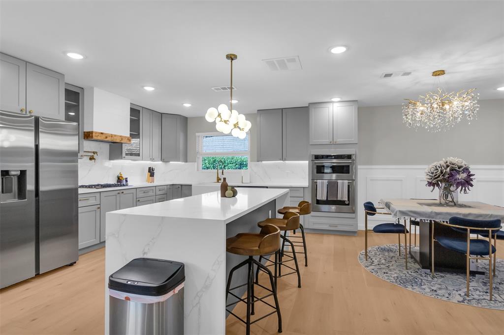 11107 Hillcrest Road Dallas, TX 75230 - Photo 24 of 29 a kitchen with stainless steel appliances kitchen island granite countertop a dining table chairs stove a refrigerator and cabinets