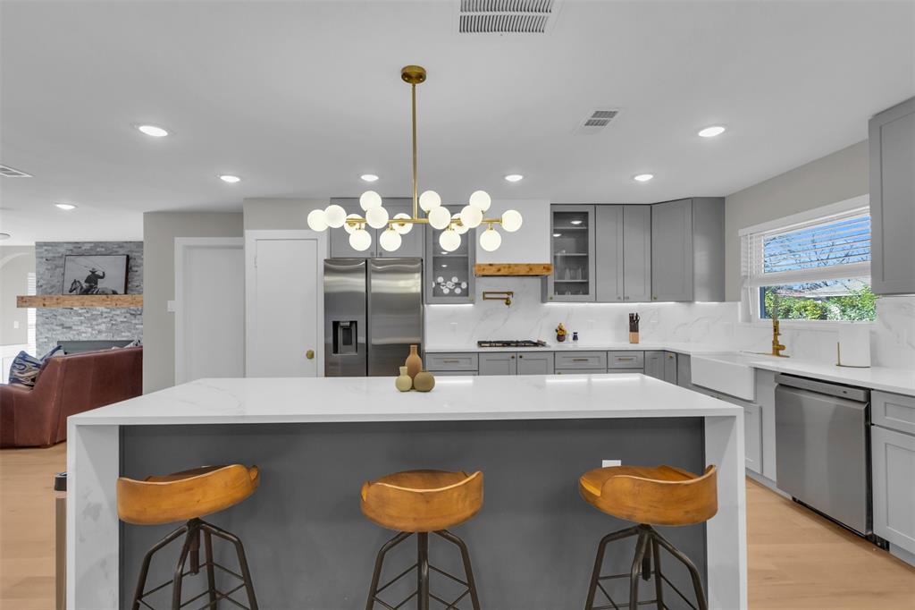 11107 Hillcrest Road Dallas, TX 75230 - Photo 3 of 29 a kitchen with kitchen island granite countertop a sink and white cabinets