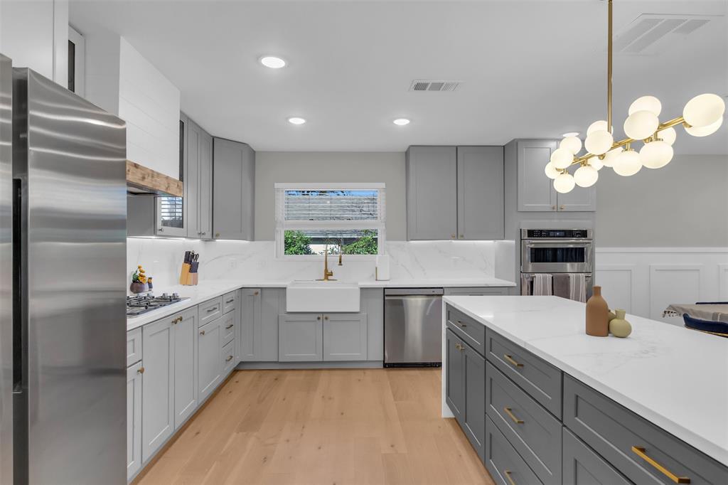 11107 Hillcrest Road Dallas, TX 75230 - Photo 5 of 29 a kitchen with kitchen island granite countertop a sink a stove and refrigerator