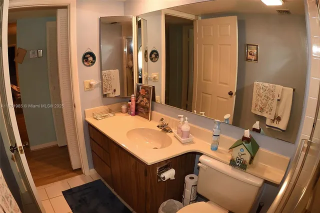 a bathroom with a sink mirror and a toilet