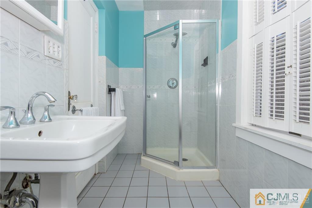 77 Rector Street Metuchen, NJ 08840 - Photo 17 of 24 a bathroom with a shower a mirror and a sink