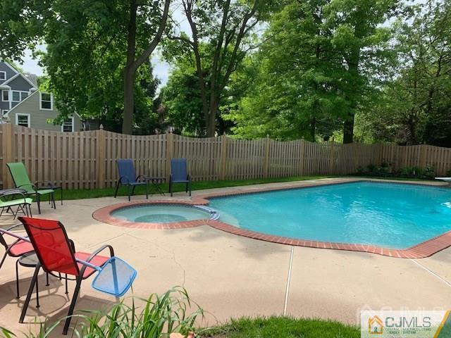 77 Rector Street Metuchen, NJ 08840 - Photo 21 of 24 a view of a backyard with table and chairs with wooden fence