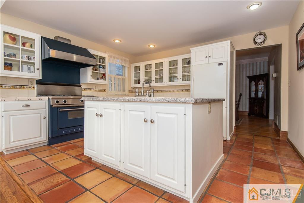 77 Rector Street Metuchen, NJ 08840 - Photo 6 of 24 a kitchen with stainless steel appliances granite countertop a stove top oven a sink dishwasher and a refrigerator with wooden floor