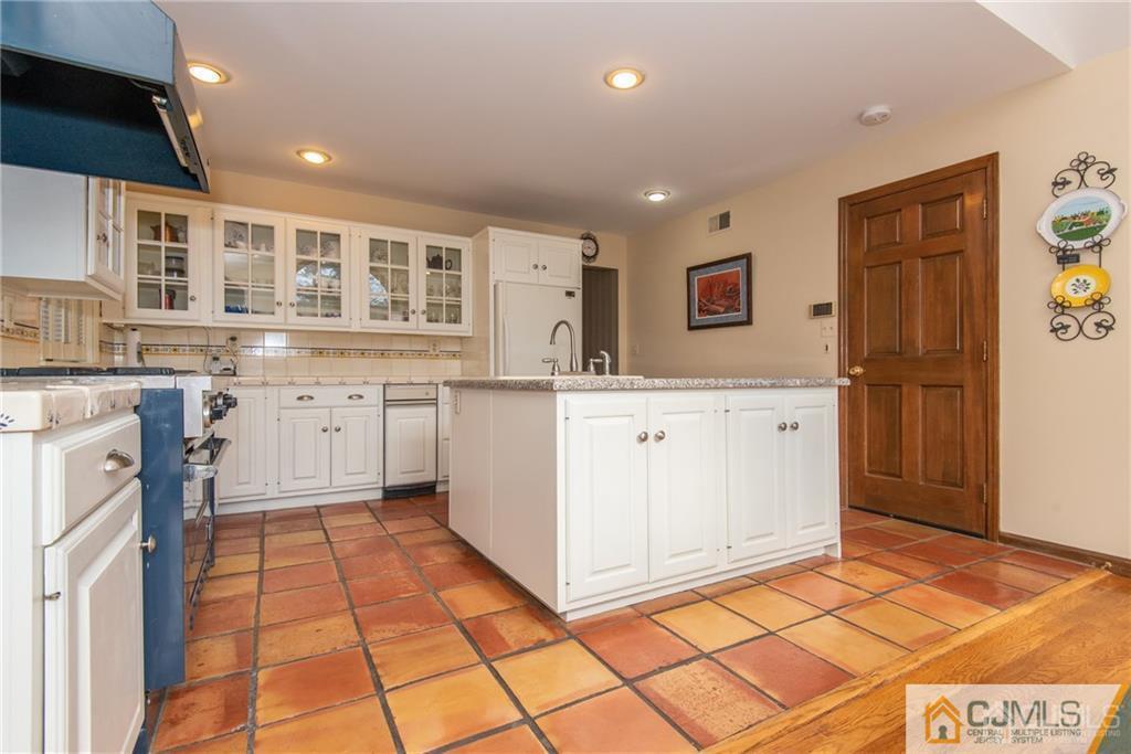77 Rector Street Metuchen, NJ 08840 - Photo 7 of 24 a kitchen with granite countertop a stove a sink and a refrigerator