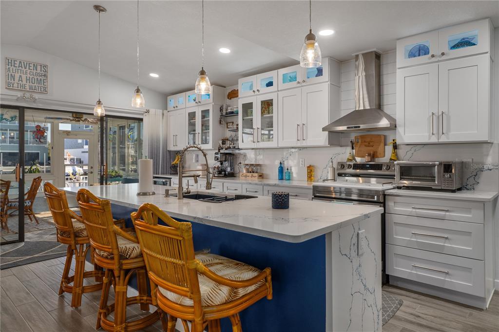 4128 Camelia Drive Hernando Beach, FL 34607 - Photo 14 of 50 a kitchen with stainless steel appliances granite countertop a kitchen island a stove a table and chairs