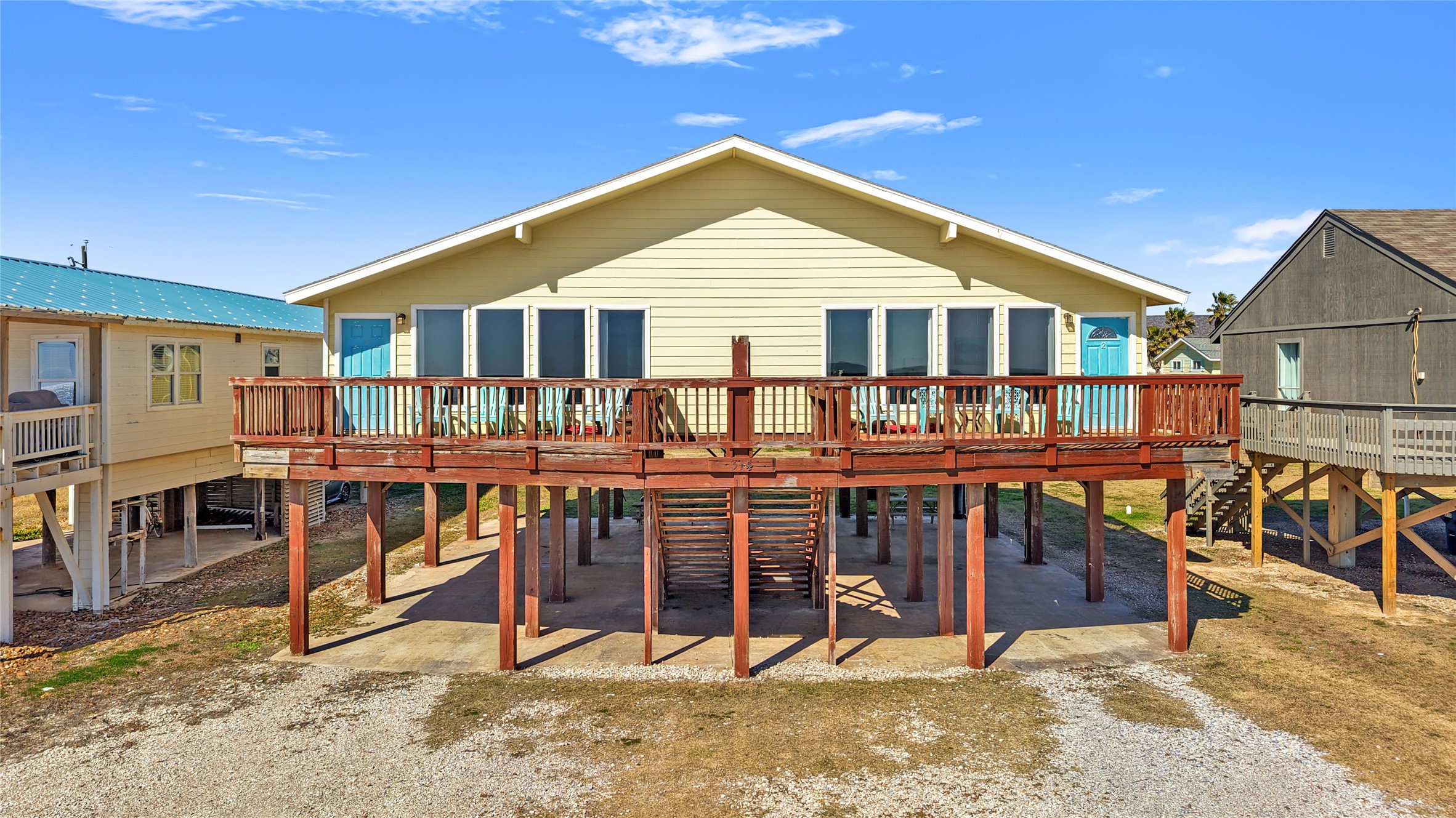 a view of a house with wooden deck and furniture