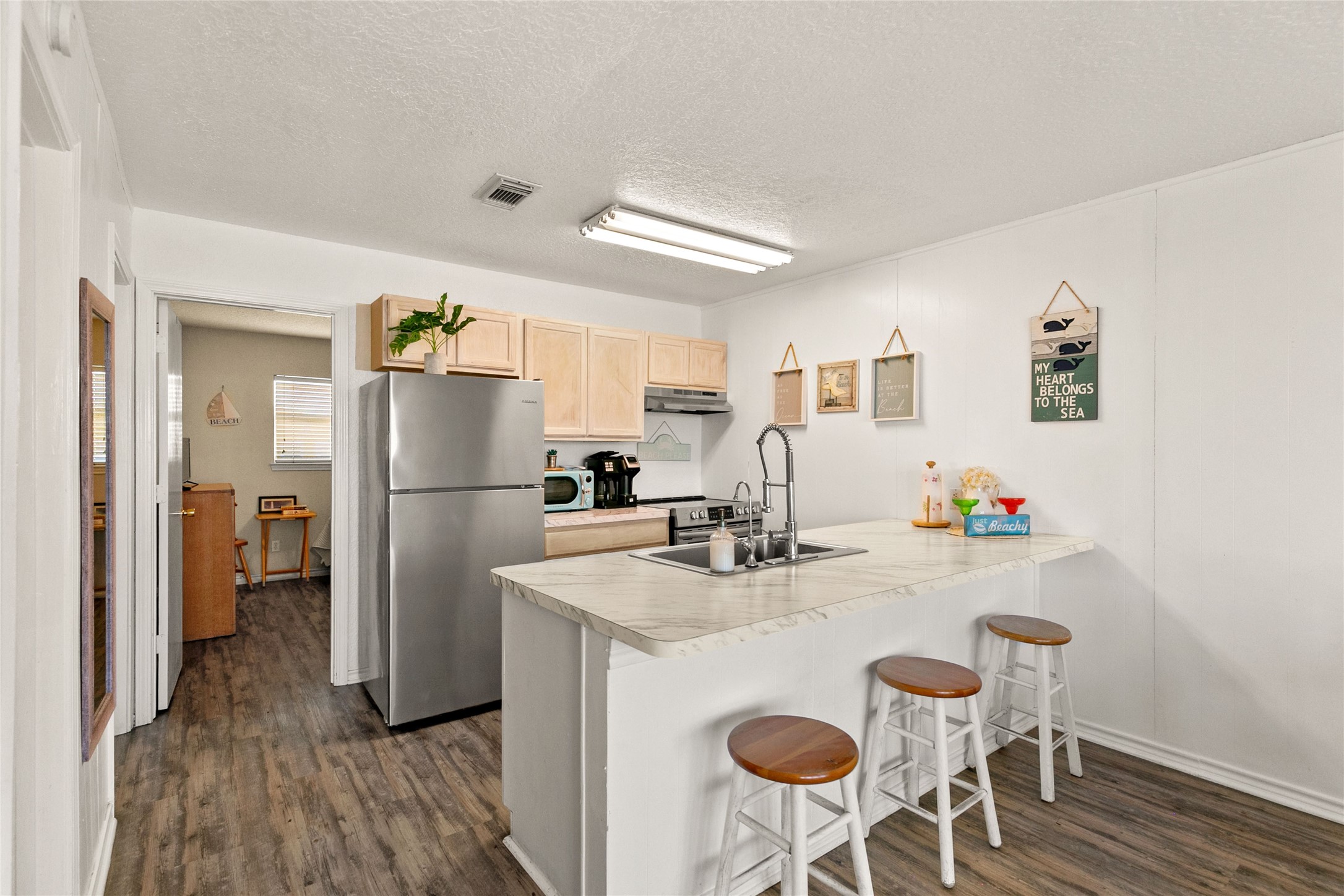 314 Beach Drive Surfside Beach, TX 77541 - Photo 27 of 38 a kitchen with refrigerator and wooden floor