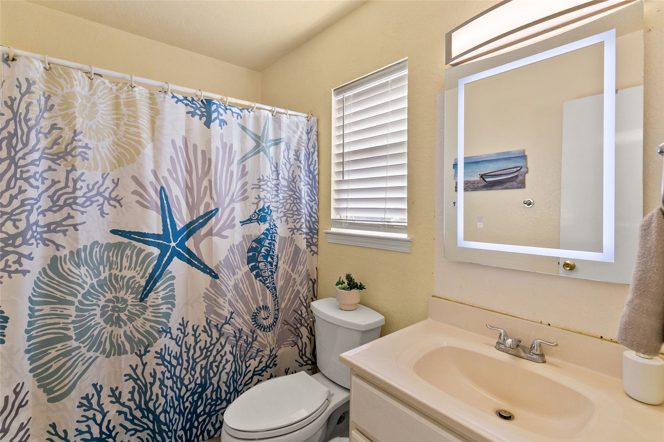 314 Beach Drive Surfside Beach, TX 77541 - Photo 31 of 38 a bathroom with a sink and mirror with toilet
