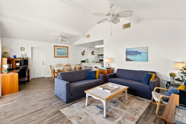 a living room with furniture a ceiling fan and a rug