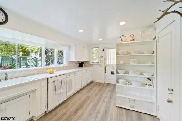 a large white kitchen with cabinets