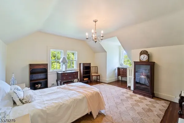 a spacious bedroom with a bed dresser and a flat tv screen