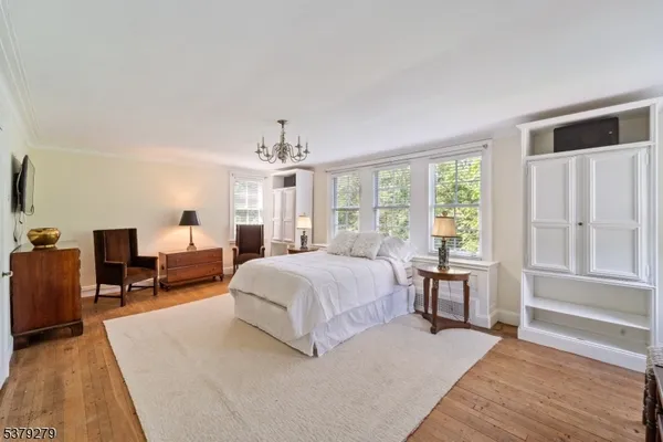 a spacious bedroom with a bed a table and chair