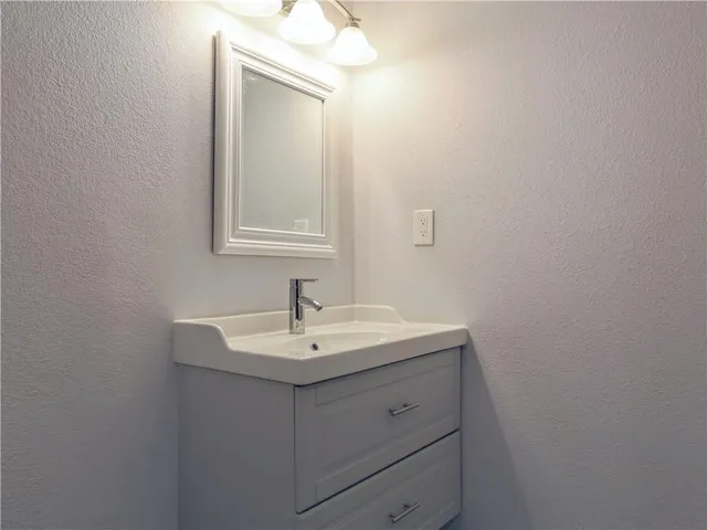 a bathroom with a sink vanity and mirror